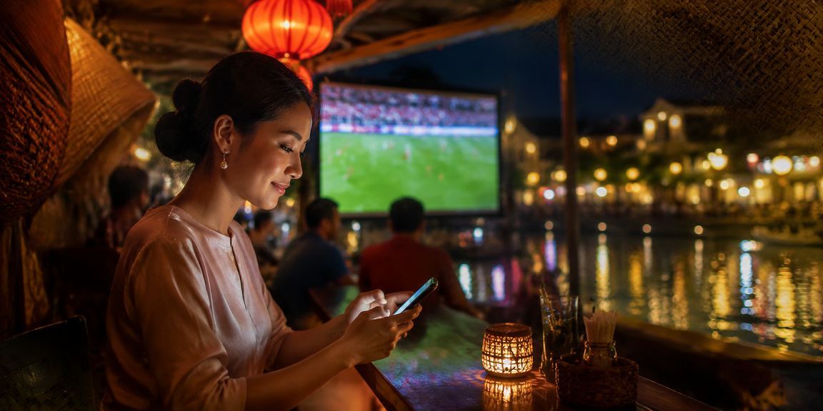 Người dùng tại Hội An theo dõi kèo bóng đá trên điện thoại buổi tối